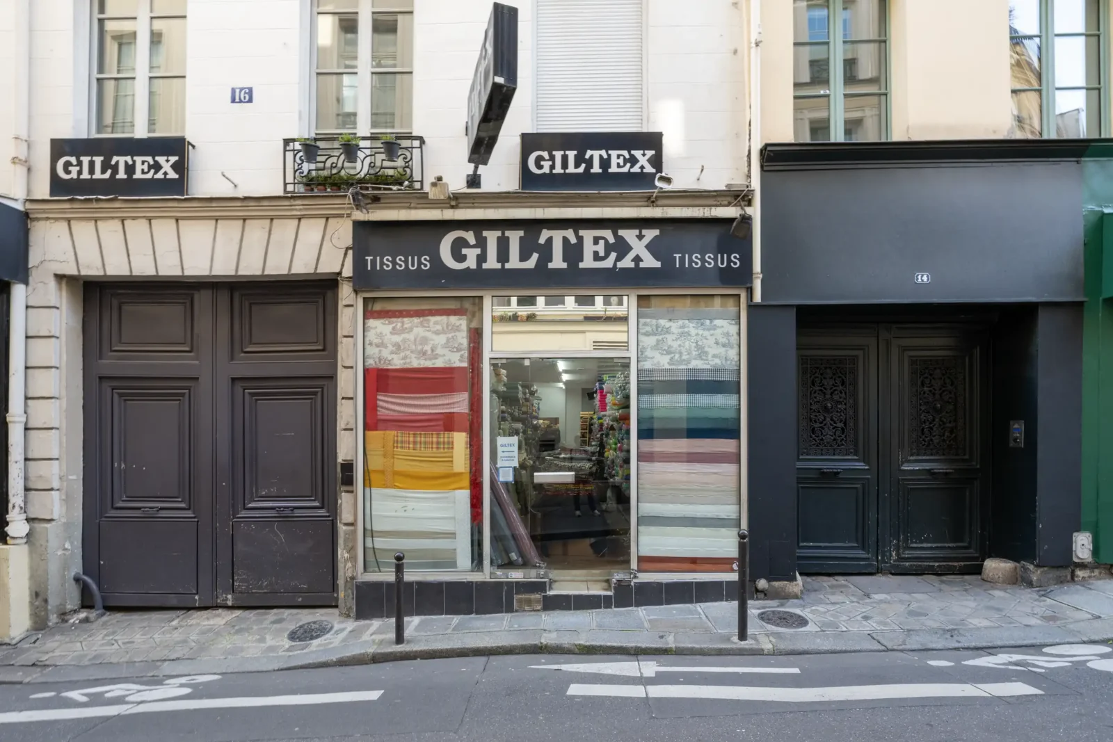 Façade d'un magasin de tissus Giltex dans une rue pavée du quartier parisien Sentier.