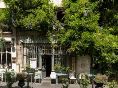 Façade ancienne du restaurant Au Vieux Paris d Arcole recouverte de verdure luxuriante.