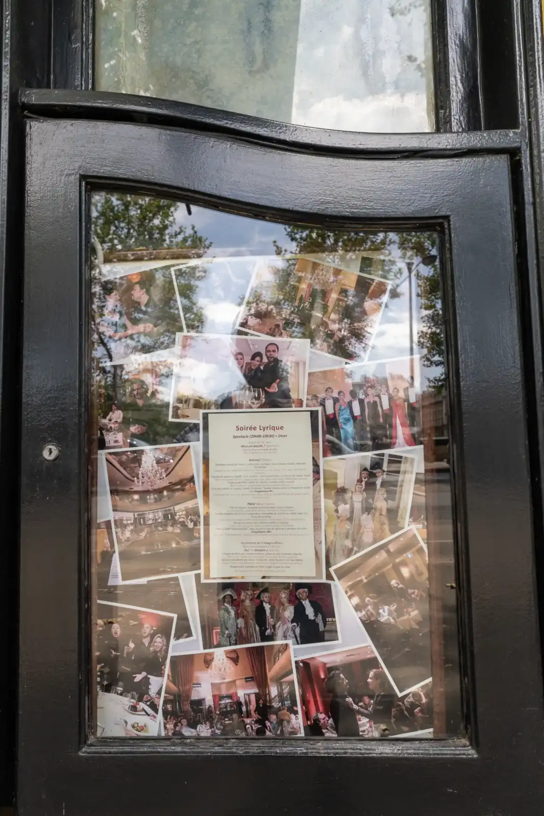 Un menu et des photos de spectacles lyriques s affichent derrière la vitrine noire du restaurant.