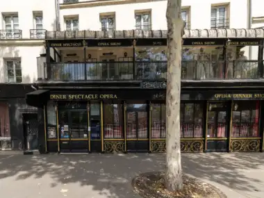 Façade noire et dorée du restaurant Bel Canto à Paris avec un grand arbre.