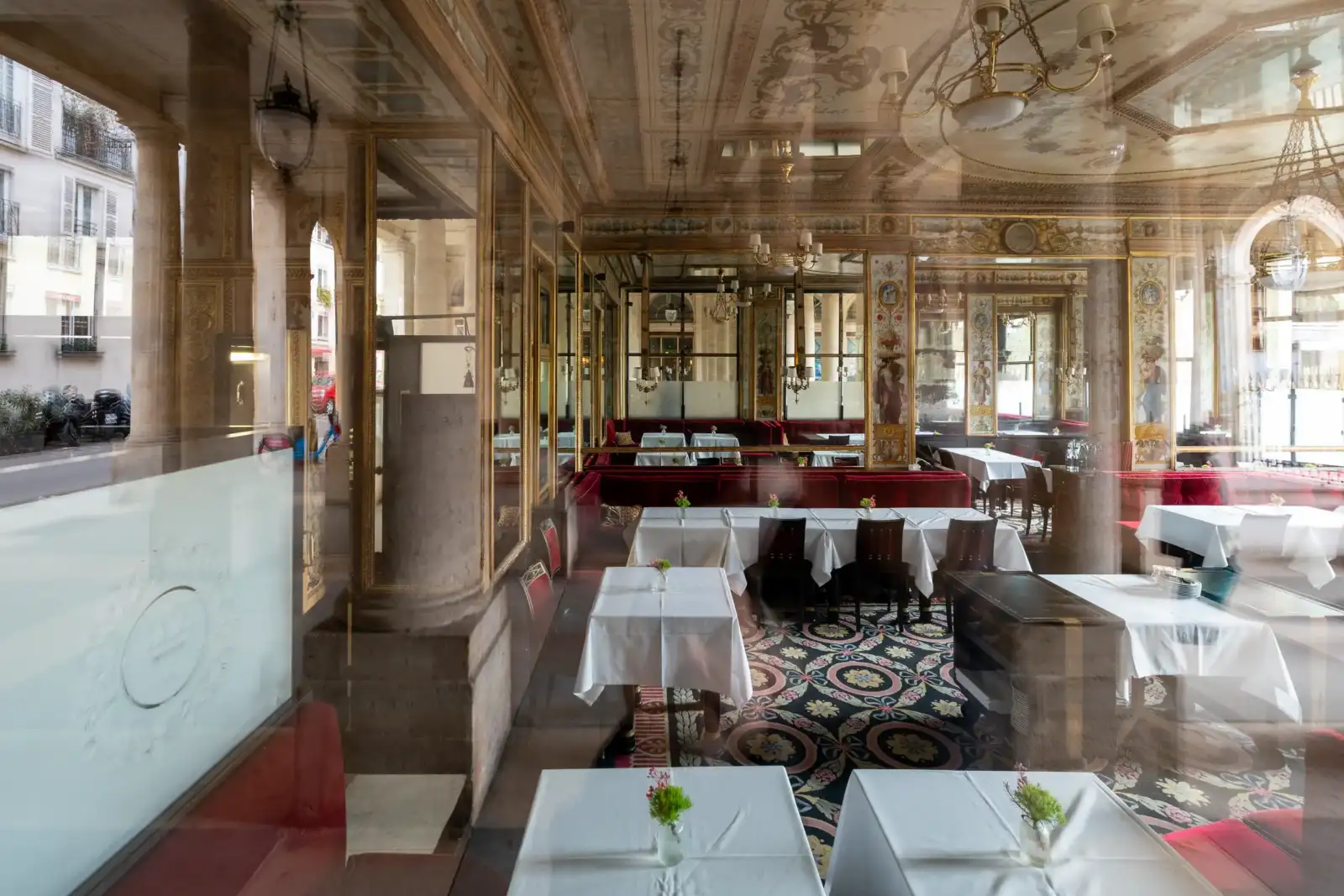 Vue à travers une vitre du luxueux intérieur historique du restaurant parisien Grand Véfour.