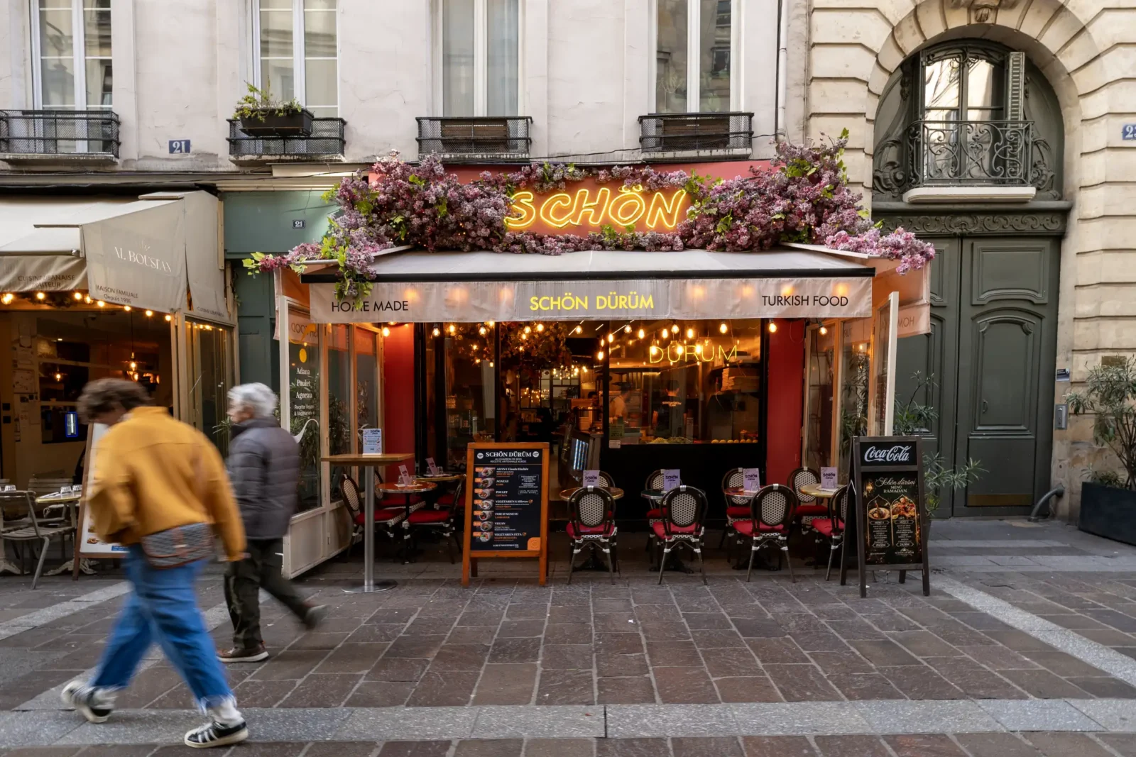 Une façade de restaurant turc fleurie et illuminée sur la rue Montorgueil à Paris.