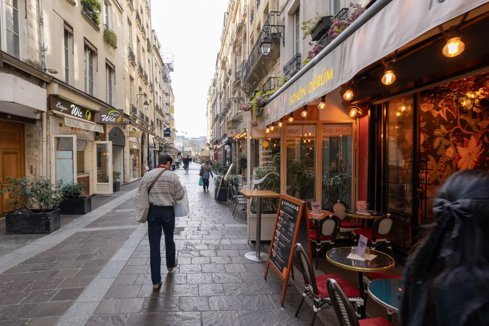 Une vue piétonne de la rue Montorgueil à Paris avec ses restaurants et commerces.