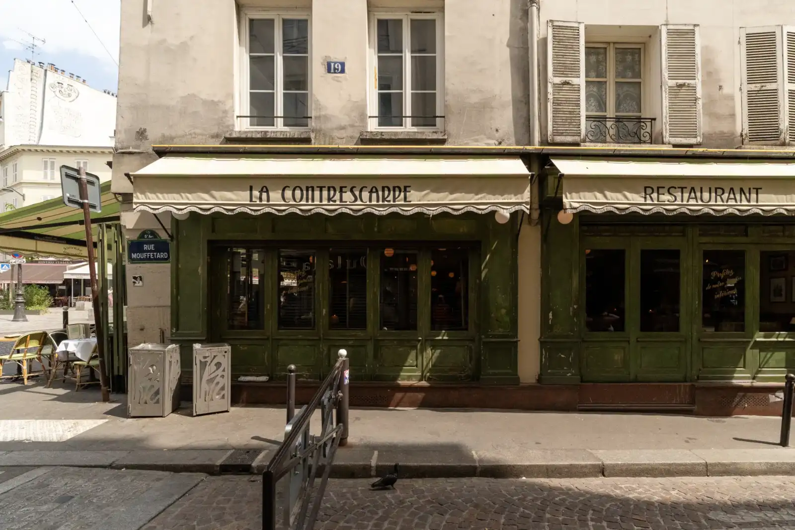 Façade d'un restaurant parisien avec une enseigne bleue indiquant la rue Mouffetard.