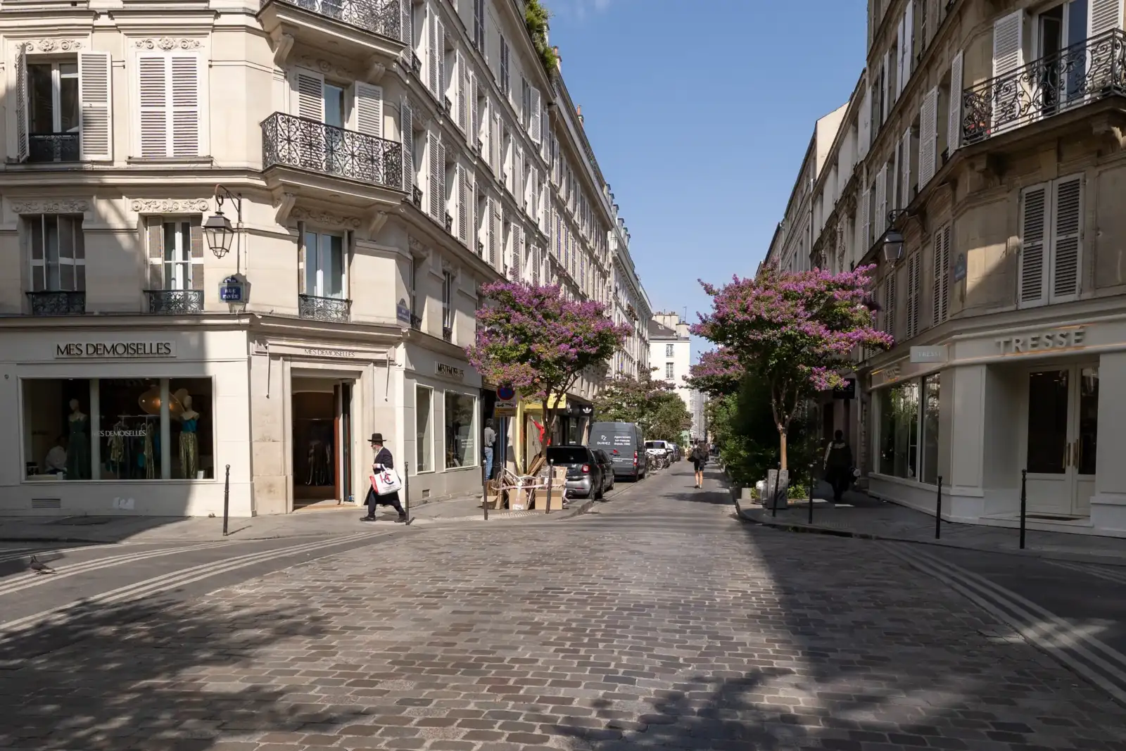 Vue de la rue des Rosiers pavée à Paris sous un ciel bleu dégagé.