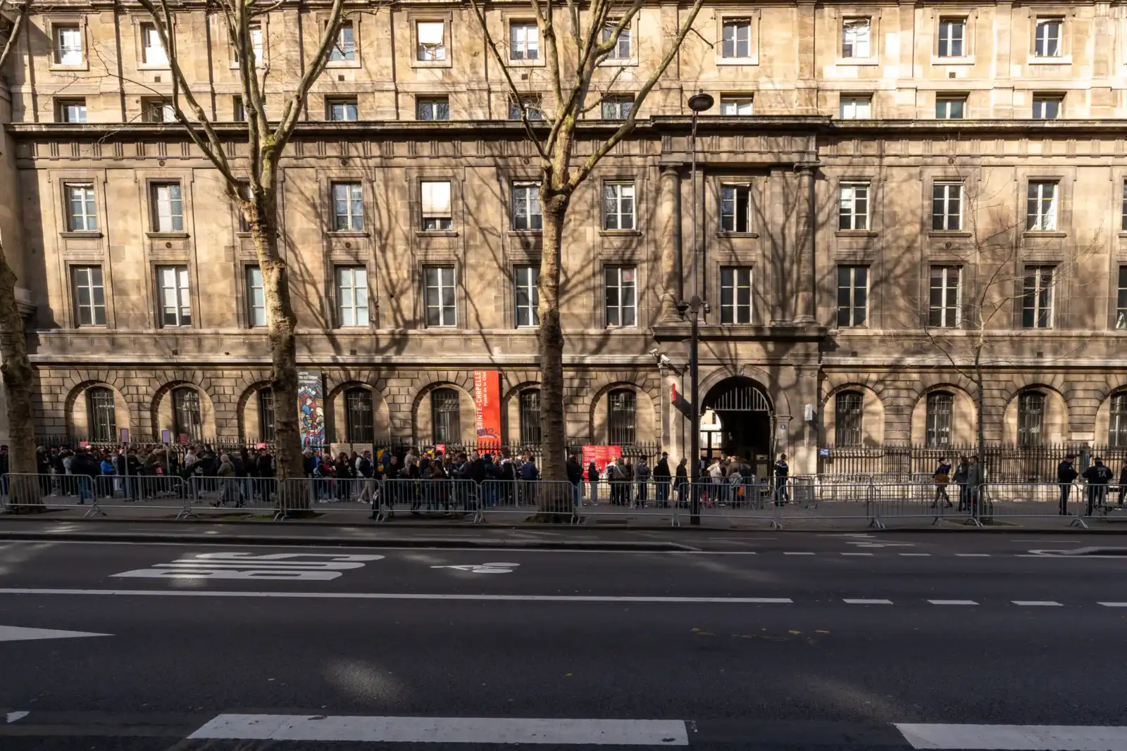 Une file d'attente s'étire devant la façade classique de la Sainte-Chapelle à Paris.