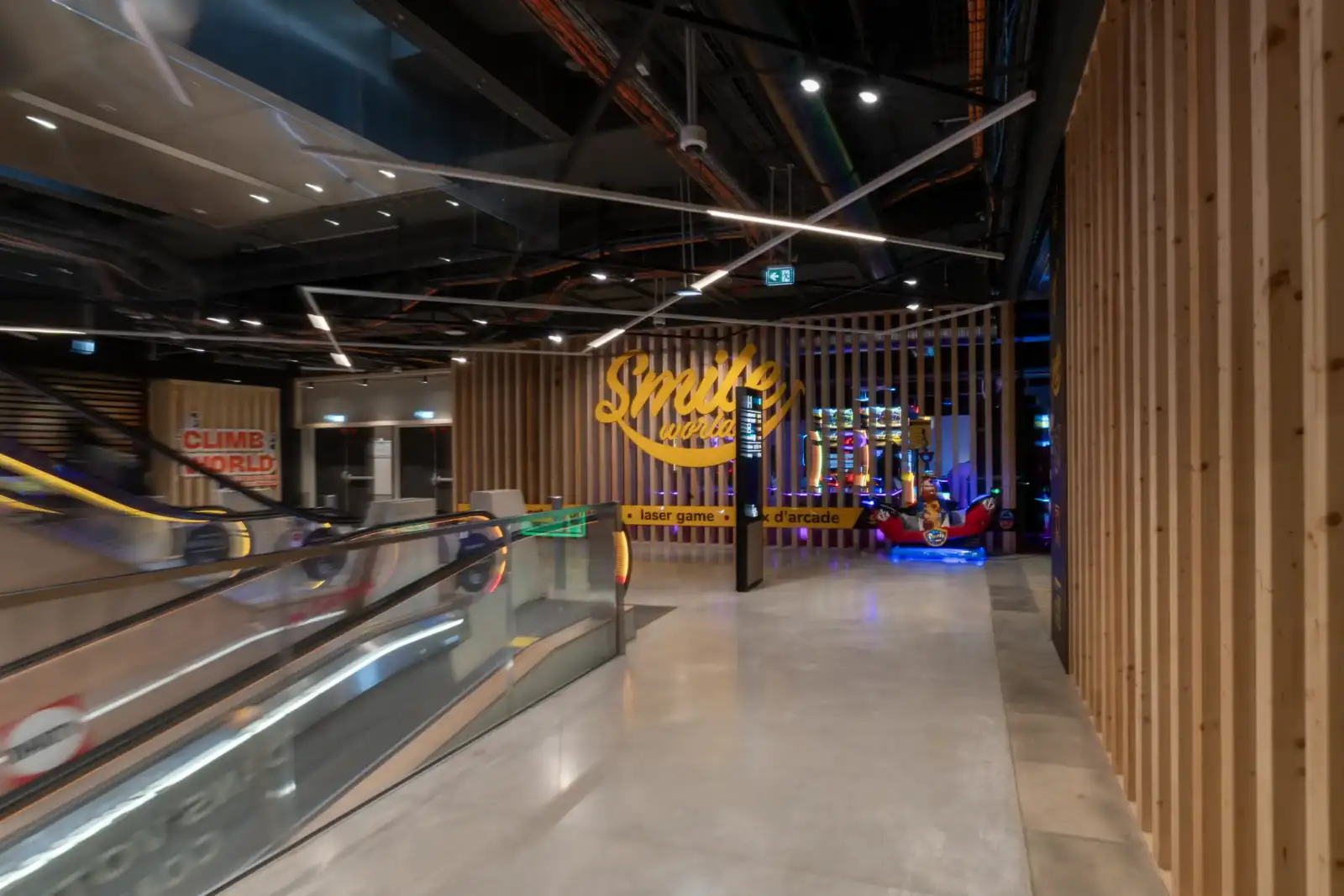 Vue intérieure de la salle de jeux Smile World à Paris avec des escalators.