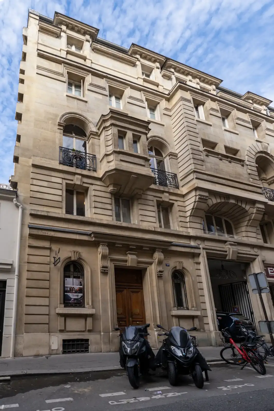 La façade beige et élégante d un immeuble parisien possède des balcons en fer forgé.