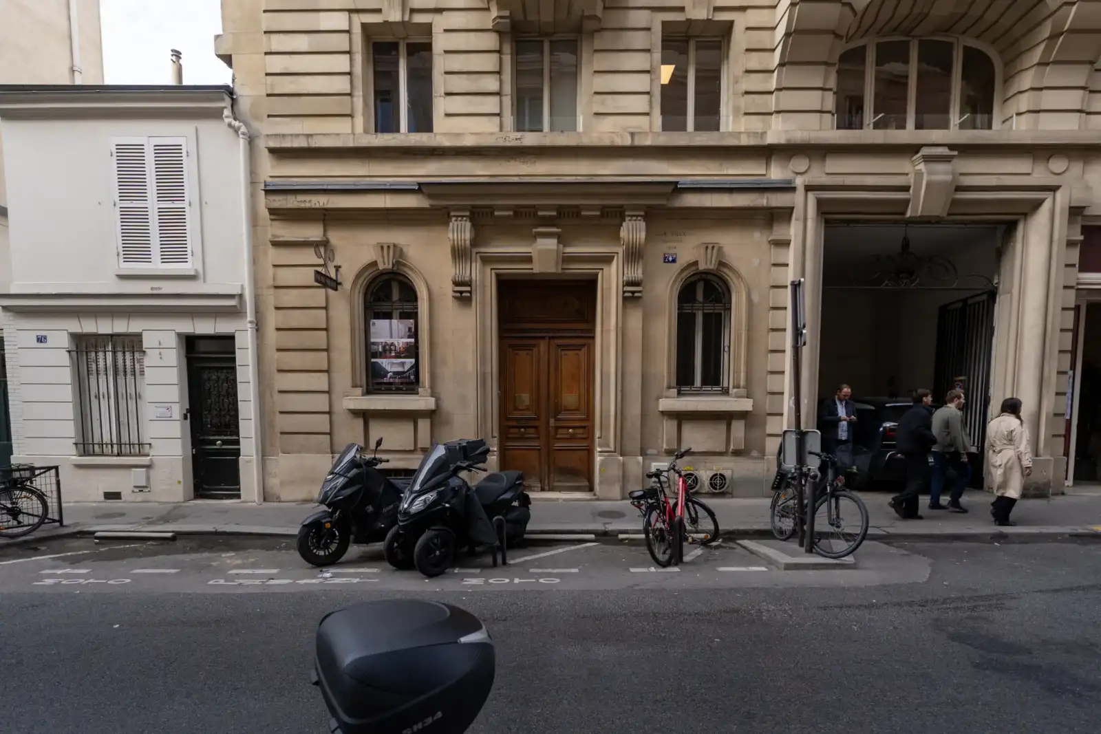 Vue de la rue du Jeu de Paume à Paris, avec des piétons et des deux-roues.