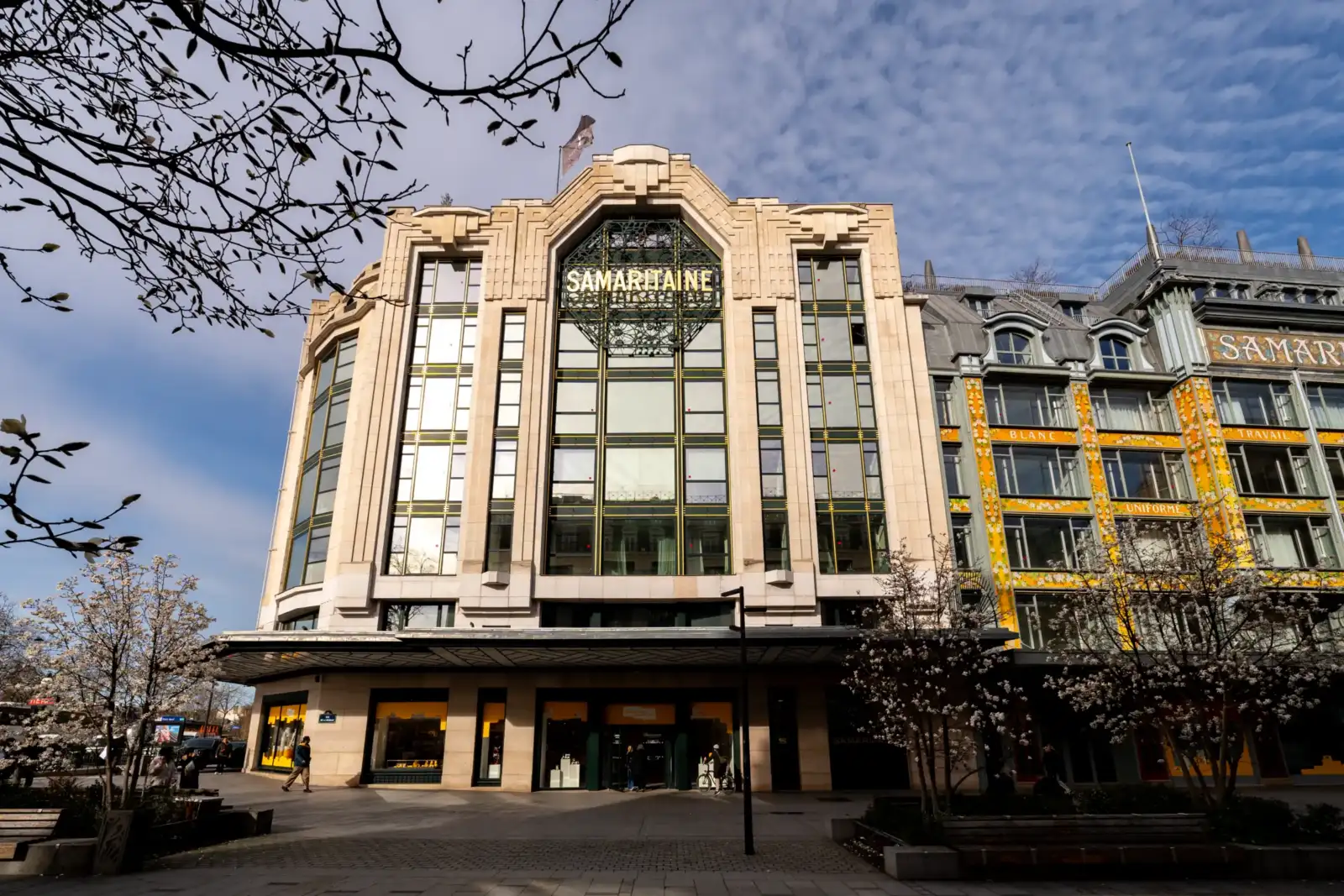 La façade art déco de la Samaritaine à Paris sous un ciel bleu ensoleillé.