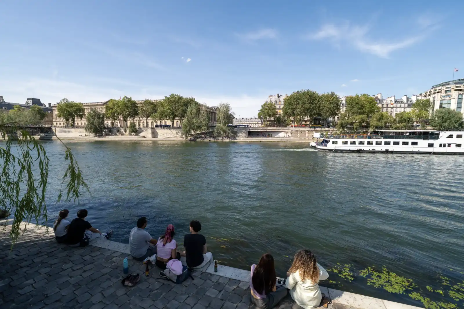 Des gens profitent de la vue sur la Seine au Square du Vert Galant.
