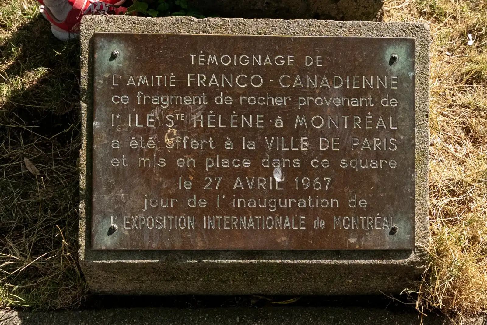 Plaque commémorative en bronze fixée sur une pierre au Square du Vert Galant.