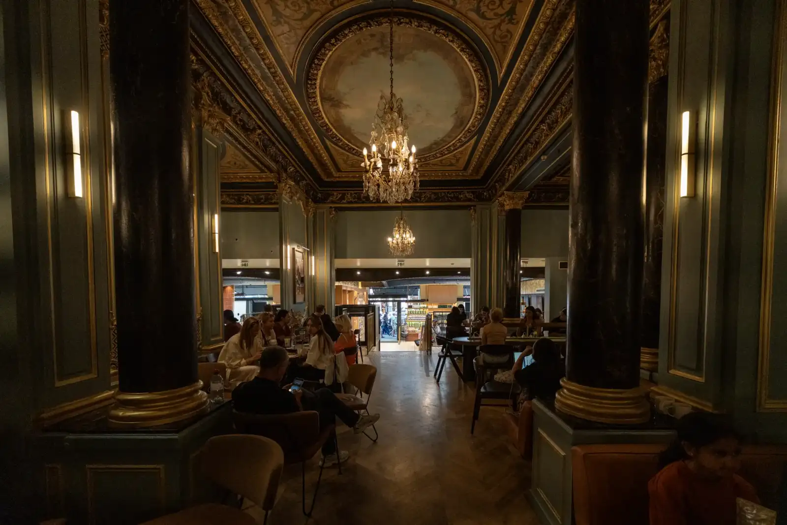 Des clients dégustent des boissons dans le magnifique décor baroque d'un Starbucks parisien.