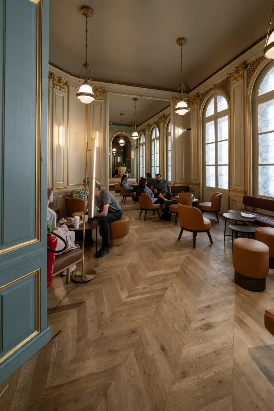 Intérieur élégant du Starbucks Opéra à Paris, avec moulures dorées et parquet en chevron.