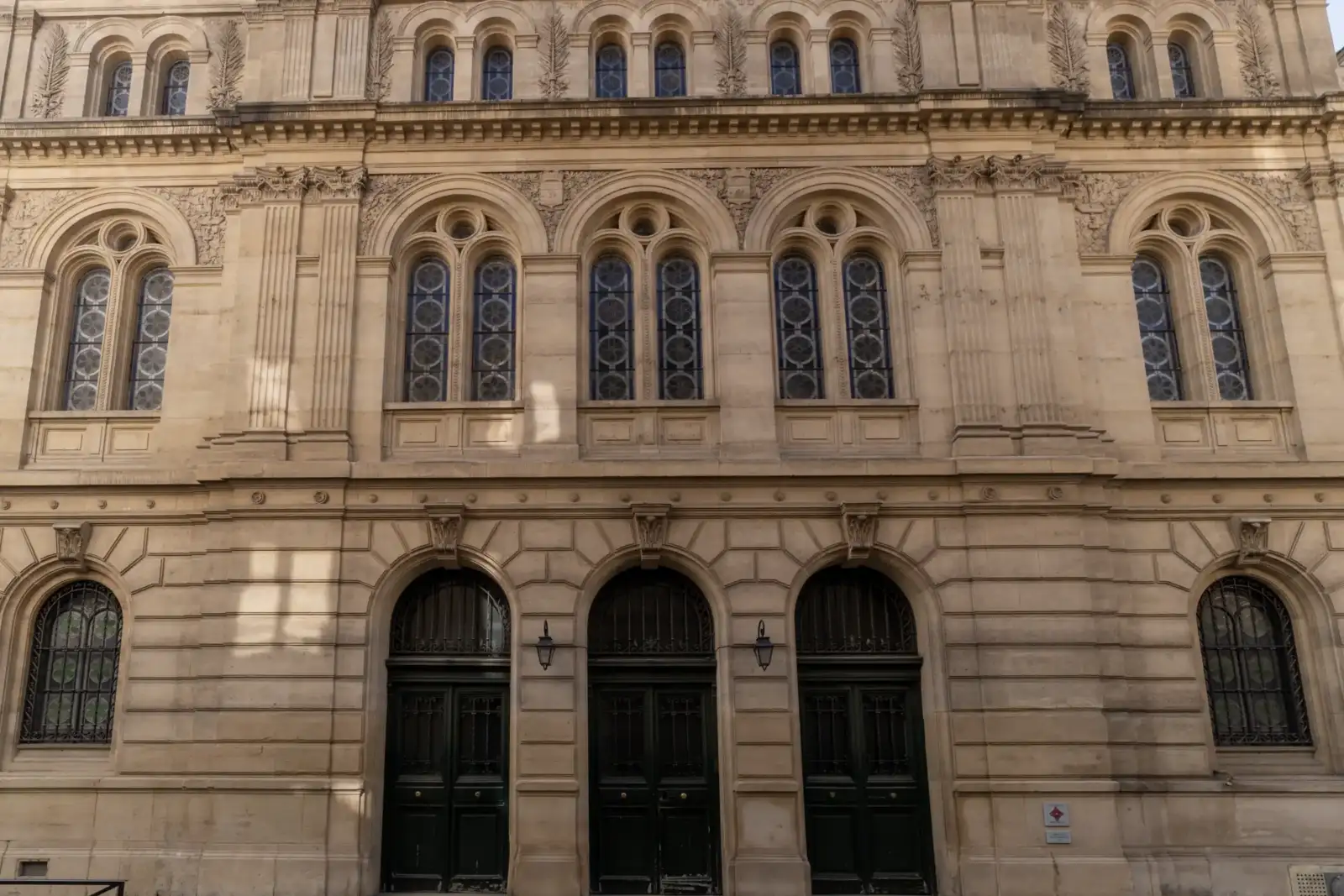 Façade monumentale en pierre claire de la synagogue des Tournées à Paris.