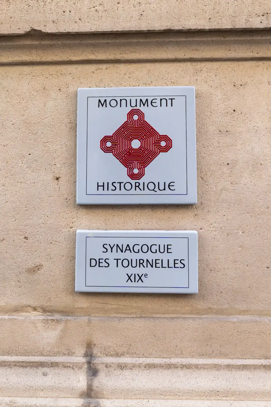 Une plaque de monument historique et une indication de la synagogue des Tournelles.