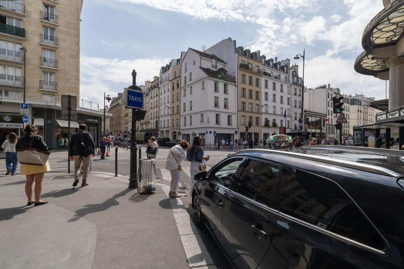 Un taxi parisien est garé sur le côté dans une rue animée de Paris.
