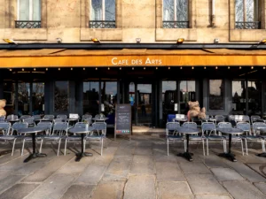 Terrasse d'un café parisien avec des chaises et deux grands ours en peluche.