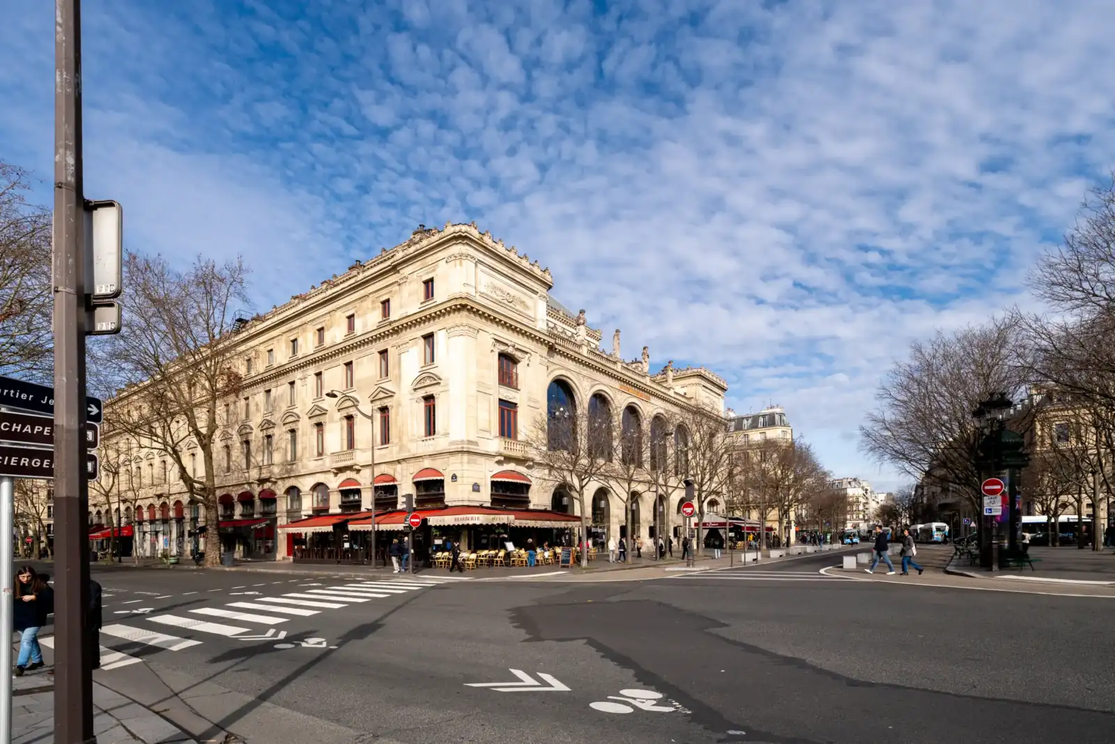 La façade du Théâtre du Châtelet à Paris sous un ciel bleu très nuageux.