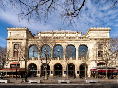 La façade classique du Théâtre du Châtelet à Paris sous un ciel bleu ensoleillé.