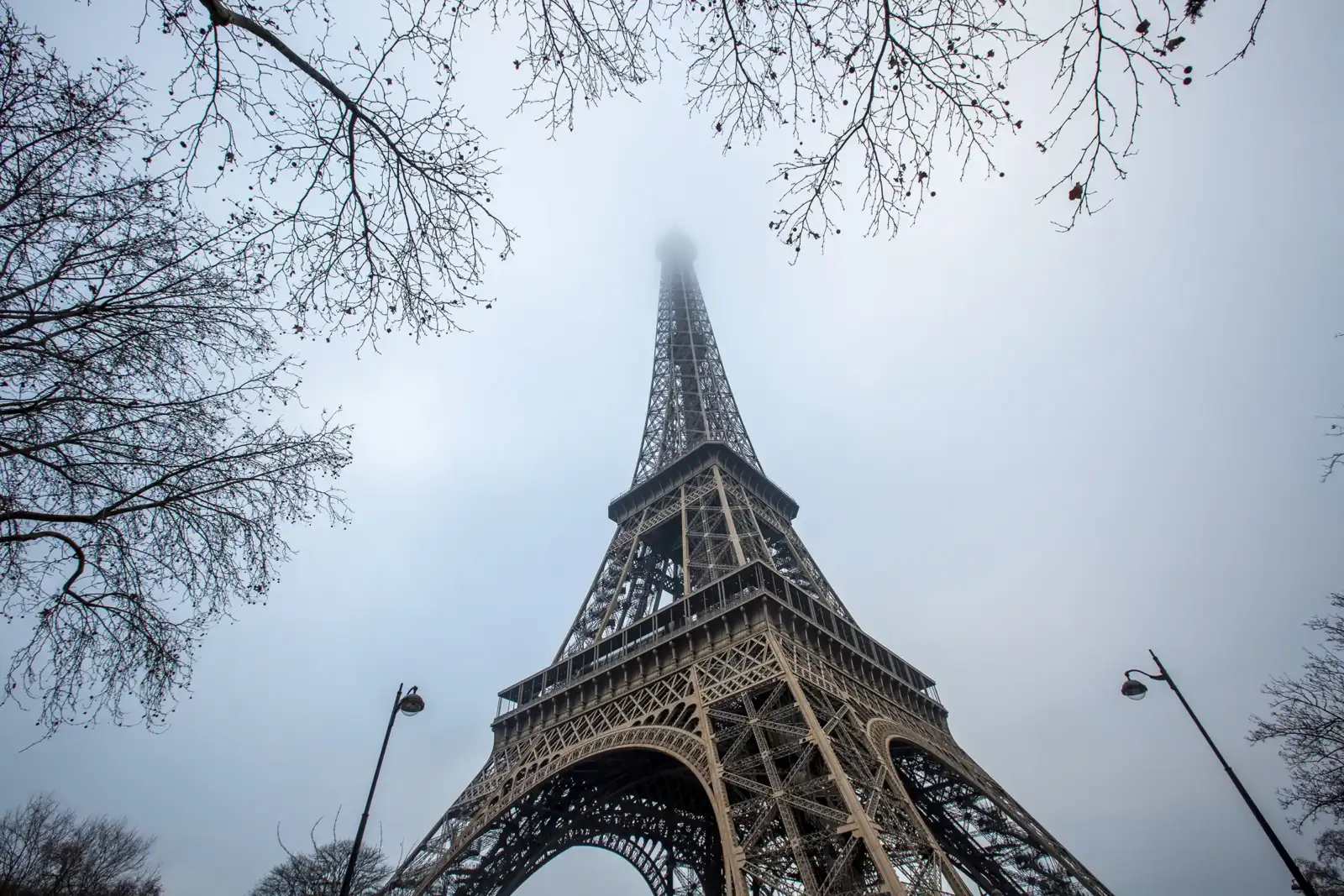 La Tour Eiffel se dresse dans le ciel gris et brumeux de Paris en hiver.