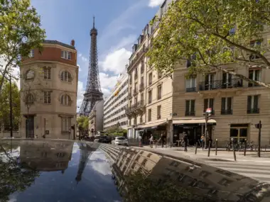 Vue de la tour Eiffel depuis une rue parisienne bordée d immeubles haussmanniens.