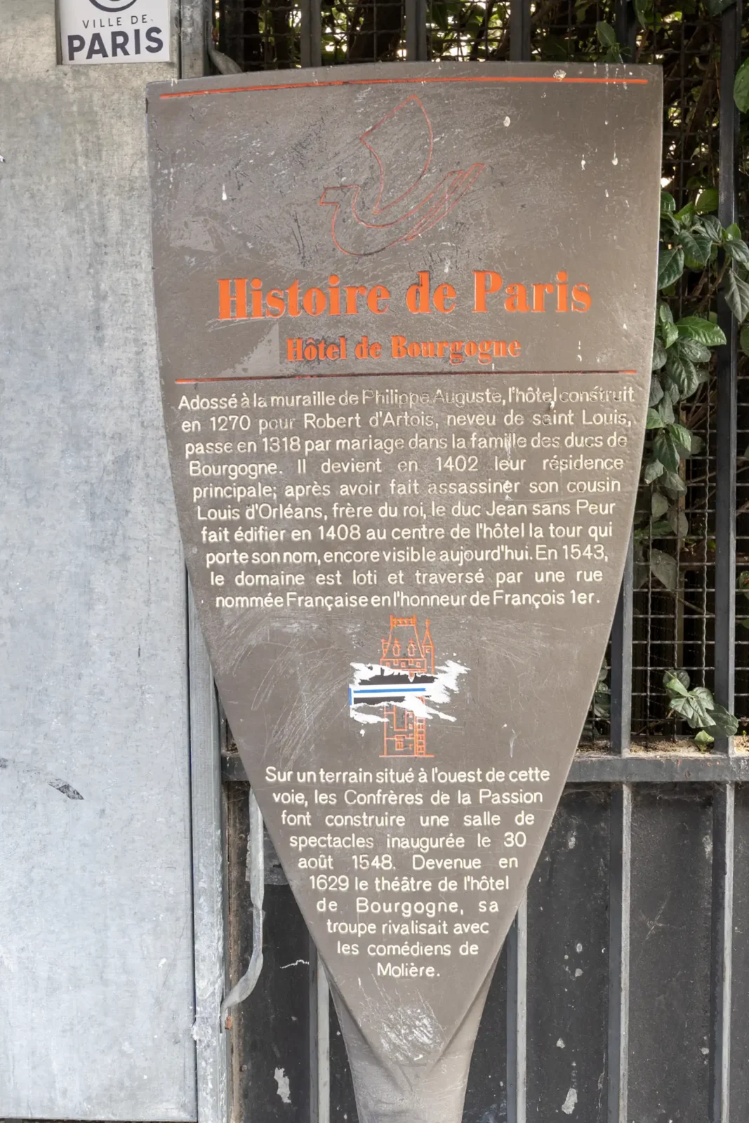 Panneau informatif en forme de blason sur l'histoire de l'Hôtel de Bourgogne à Paris.