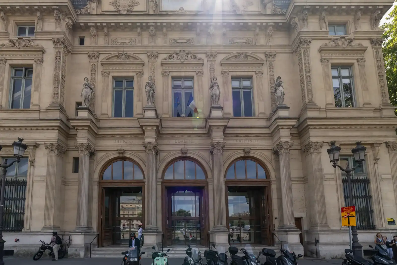 La façade sculptée du tribunal de commerce de Paris affiche des statues et drapeaux.